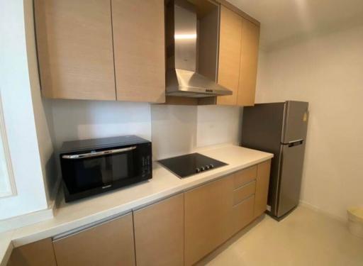 Modern kitchen with wooden cabinets, stainless steel appliances and white countertop