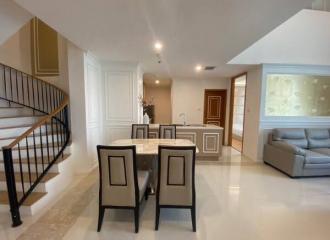 Modern dining space with open concept leading to a living area and staircase