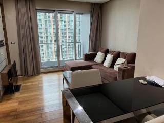 Modern living room with large windows and brown sectional sofa