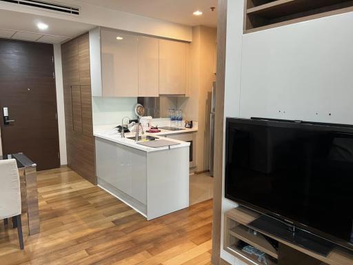 Modern living room with integrated kitchen space and wooden flooring