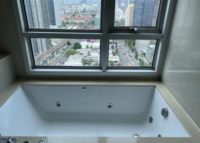 Modern bathroom with large jacuzzi tub and city view through window