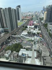 Cityscape view from a high-rise building showing urban surroundings with dense traffic and buildings