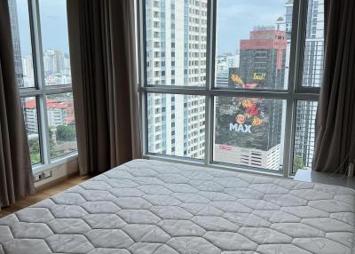 Cozy bedroom with large windows and city view