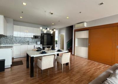 Modern apartment interior with open floor plan including kitchen, dining, and living area
