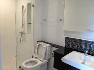 Modern bathroom with glass shower, white fixtures, and black vanity