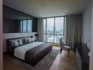 Modern bedroom with a panoramic city view through floor-to-ceiling windows