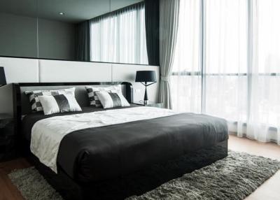 Modern bedroom with a large bed and expansive window