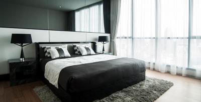 Modern bedroom with a large bed and expansive window