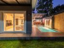 Elegant outdoor pool area with adjacent dining area and open sliding doors leading to the interior