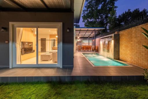 Elegant outdoor pool area with adjacent dining area and open sliding doors leading to the interior