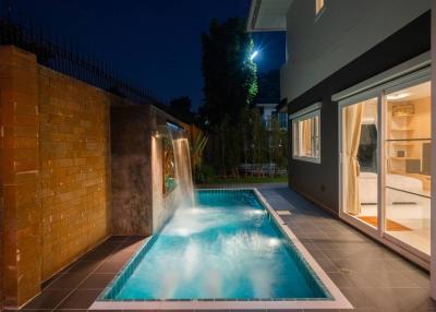 Modern home exterior with swimming pool at twilight