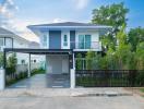 Contemporary two-story house with a blue facade and spacious driveway