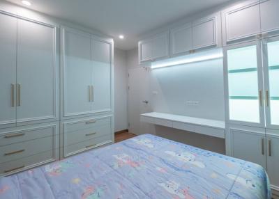 Spacious bedroom with built-in wardrobes and modern lighting