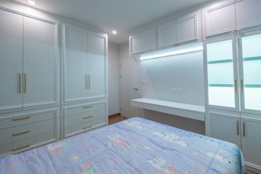 Spacious bedroom with built-in wardrobes and modern lighting