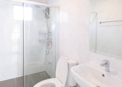 Modern bathroom interior with a glass shower, white toilet, and sink