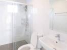 Modern bathroom interior with a glass shower, white toilet, and sink