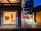Modern home exterior with swimming pool and patio area during evening