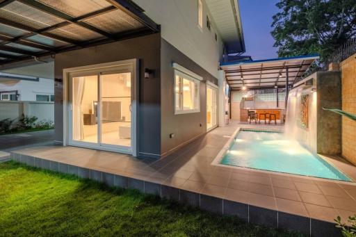 Modern house exterior with pool and patio area at dusk