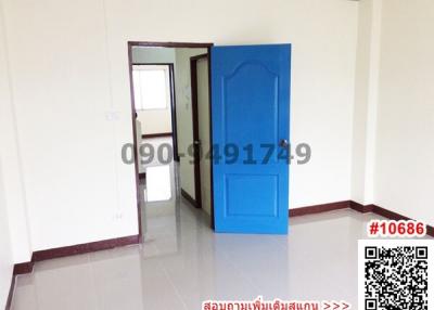 Spacious empty room with blue door and white walls