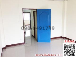 Spacious empty room with blue door and white walls