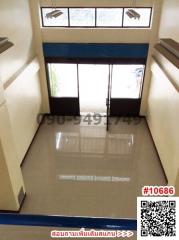 Spacious and well-lit corridor in a modern building with large windows and glass door