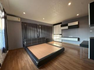 Spacious modern bedroom with large bed and glossy built-in cabinets
