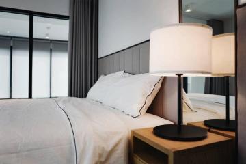 Modern bedroom with a comfy bed and elegant bedside lamp