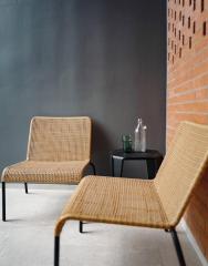 Modern minimalist chairs in a stylish interior with dark wall and brick accent