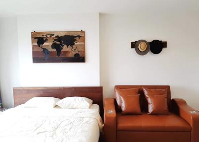 Cozy bedroom with a world map wall art and an elegant leather sofa