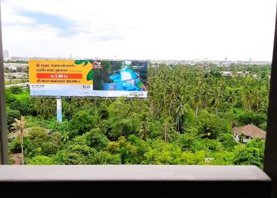 View from a balcony overlooking lush greenery and an outdoor billboard