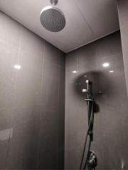 Modern bathroom with a spacious walk-in shower and dark tiles