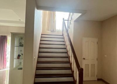 Staircase leading to the upper level of a home with a view into a well-lit hallway