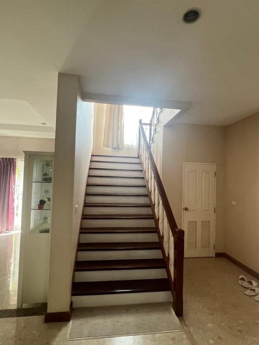 Staircase leading to the upper level of a home with a view into a well-lit hallway