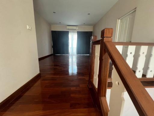 Spacious living room with natural wood flooring and large windows