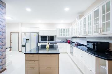 Modern spacious kitchen with white cabinetry and stainless steel appliances