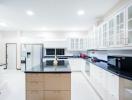 Modern spacious kitchen with white cabinetry and stainless steel appliances