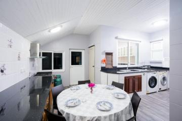 Spacious modern kitchen with dining area, white cabinetry, and appliances