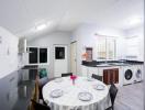 Spacious modern kitchen with dining area, white cabinetry, and appliances