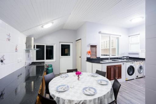 Spacious modern kitchen with dining area, white cabinetry, and appliances