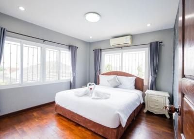 Bright and inviting bedroom with wooden floors and large windows