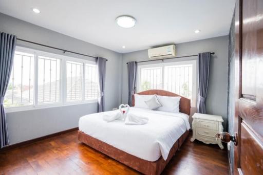 Bright and inviting bedroom with wooden floors and large windows