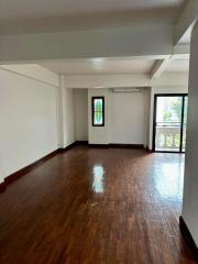 Spacious empty room with hardwood floors and abundant natural light