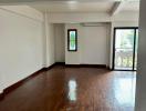 Spacious empty room with hardwood floors and abundant natural light