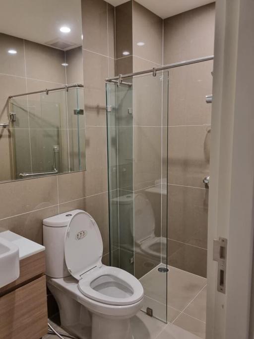 Modern bathroom with glass shower enclosure and beige tiles