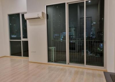 Spacious bedroom with large windows and city view at night