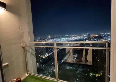 High-rise balcony overlooking a nighttime cityscape