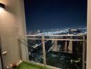 High-rise balcony overlooking a nighttime cityscape