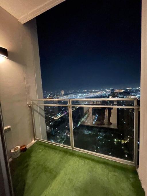 High-rise balcony overlooking a nighttime cityscape