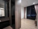 Modern bedroom interior with wooden flooring, large wardrobe, and city view through the window at night