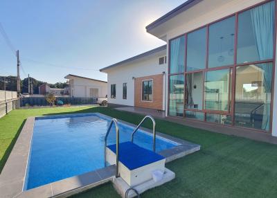 Modern home exterior with swimming pool and lawn